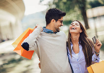 happy couple shopping with bags and credit card